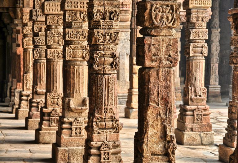 clothing-store-984396_960_720 Stone pillars with intricate carvings in an ancient architectural setting, featuring detailed patterns and designs.