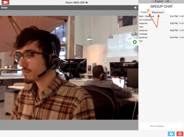 A person wearing a headset sits at a desk in a shared office space. A chat interface is visible on the right side of the image.