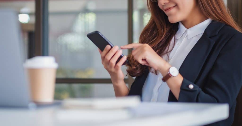 Closeup image of a businesswoman using mobile phone in office