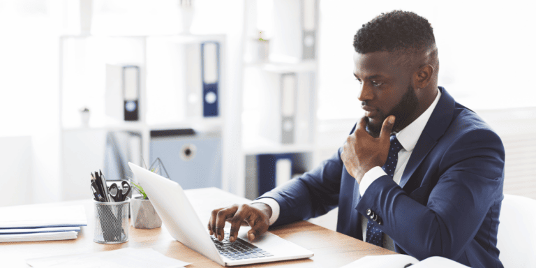 competitor analysis a person in a suit sitting at a desk with a laptop