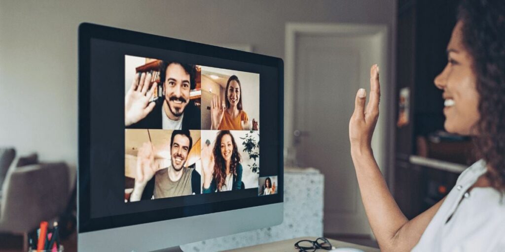 A researcher waving to participants on a video focus group